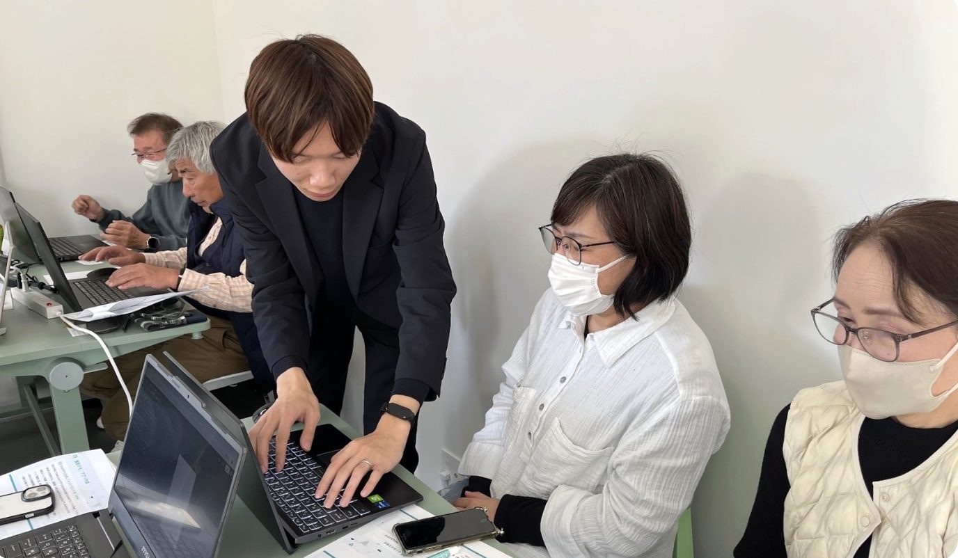 熊本県甲佐町でのAI活用講座で、地域住民の方にサポートするSystemSのメンバー